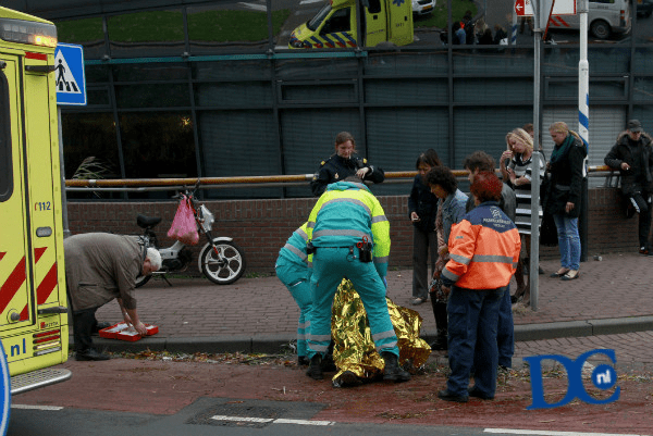 Vrouw onderuit met brommer op Spuiboulevard Vrouw onderuit met brommer op Spuiboulevard