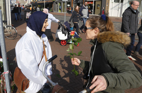 Vrijwilligers Moskee Aksa delen rozen uit Bagijnhof Dordrecht